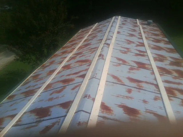 Rusted metal roof panels with new wood purlins before replacement — Storm Damage Roof Repair in South Tamworth by Roofing Brothers