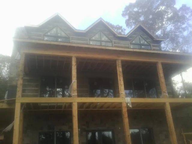 Dormers and porch framing on a large log home under construction — Roof Coating work by our crew in South Tamworth